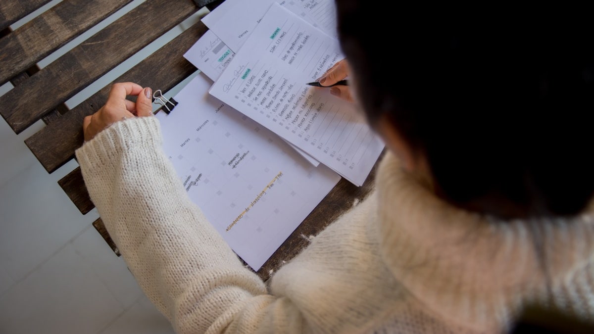 person in white long sleeve shirt writing on white paper